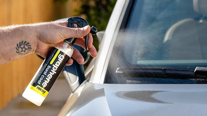 Hand of a man spraying Torque Detail Graphene Burst Coat on a car.