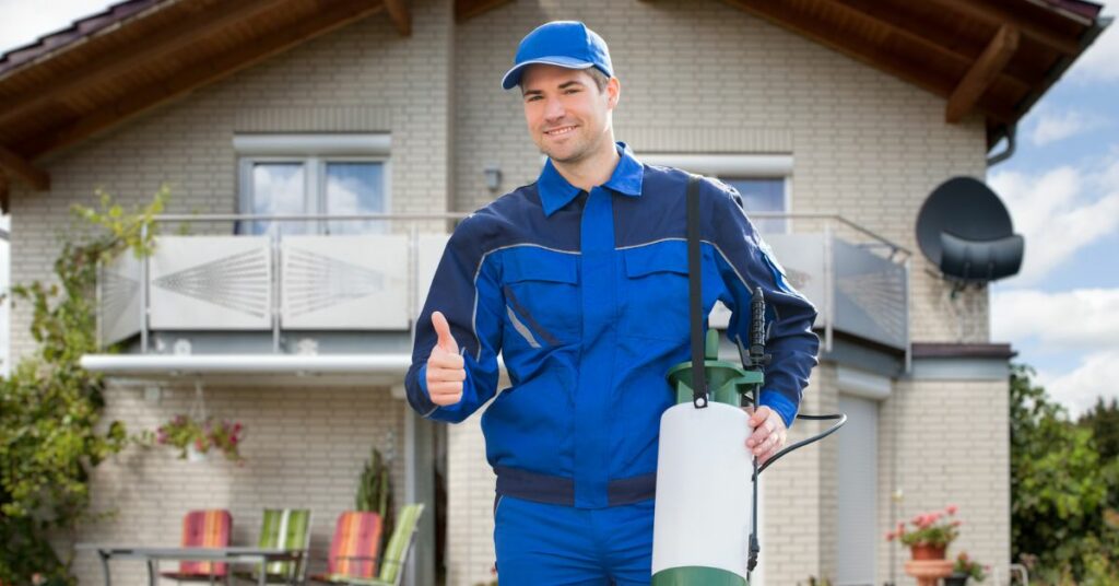 The image portrays a car professional who is well-equipped with pest control management tools. He is seen smiling and giving a thumbs-up sign.