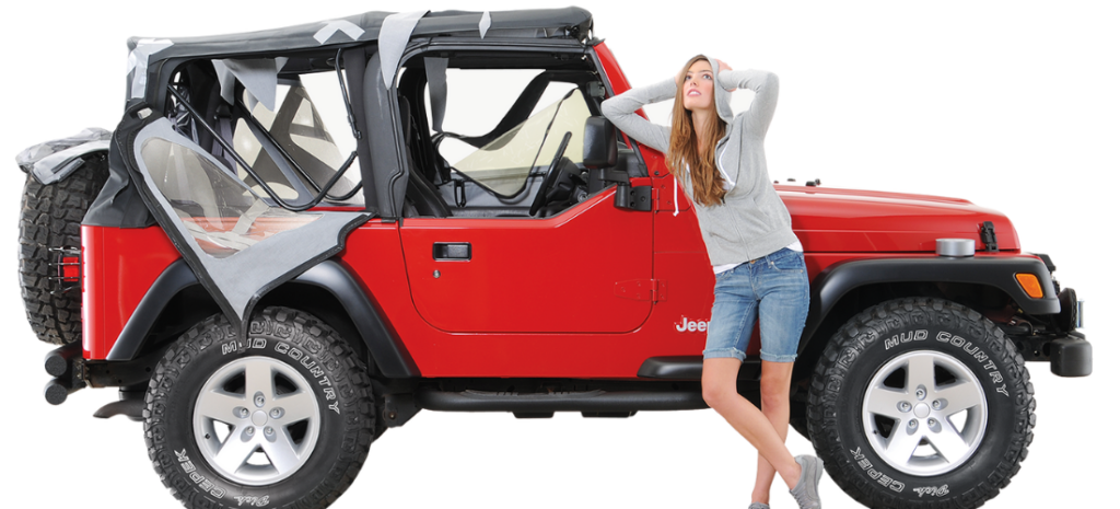 A young woman stands beside her vibrant red Jeep Wrangler, her expression tinged with concern for the deteriorating soft top.