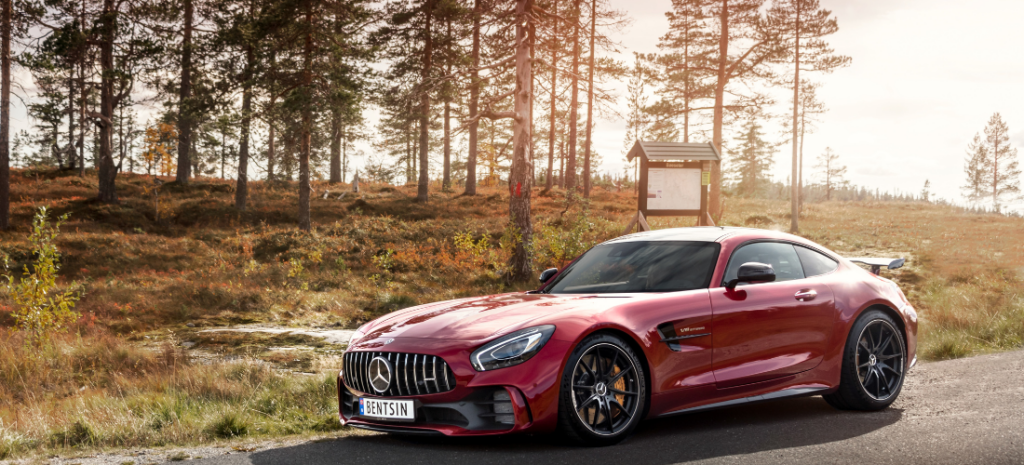 A brilliant red Mercedes car takes center stage against a picturesque background.