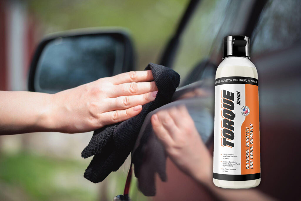 Cropped view of a hand gently rubbing the surface of the car using a soft microfiber towel with Torque Detail's Reverse.