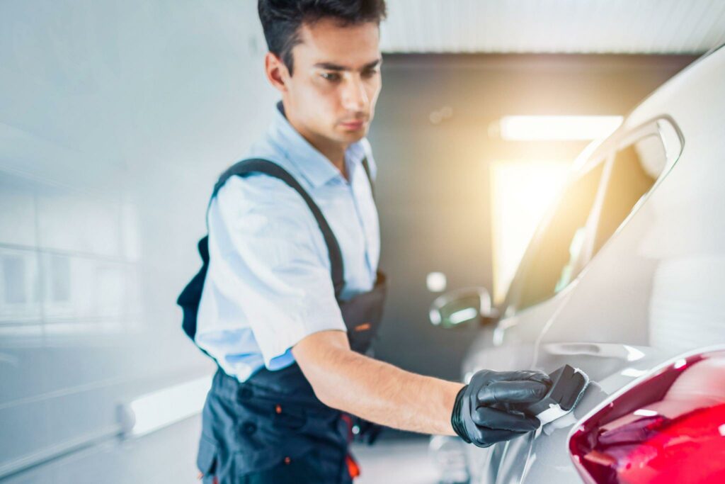 Man applying a protective coating to a car.