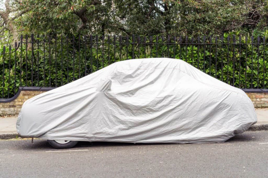 Covered car parked on the street.