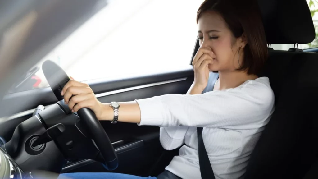 Girl having trouble with bad smelling car interior.