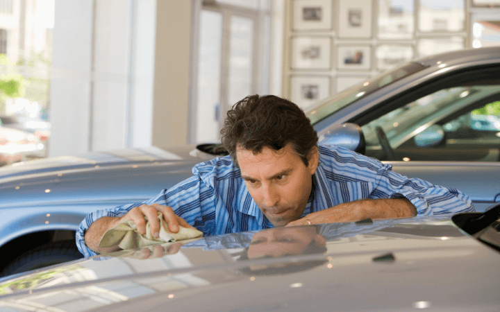 Man with a Micro fiber cloth waxing a car