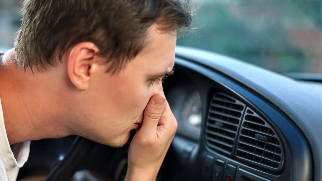 Man smelling nasty odor coming from car's AC duct.