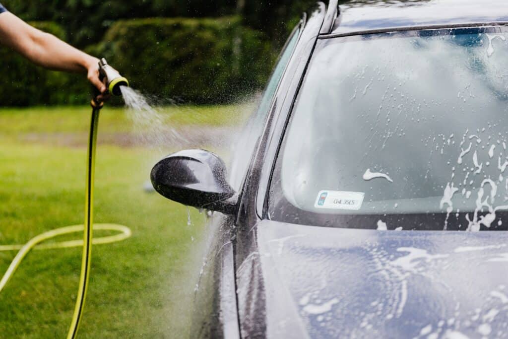 Washing exterior of the car using garden house.