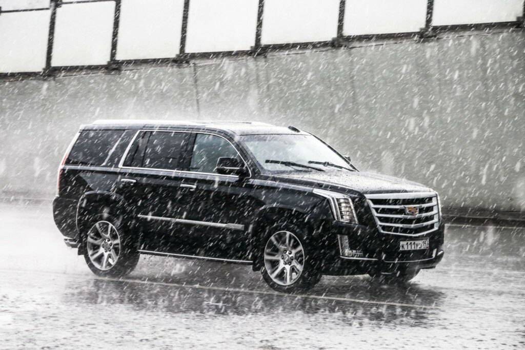 Black SUV in the city street during a heavy rain.